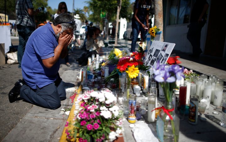 Jose Cardoso cries in front of a makeshift memorial for UCSB student Christopher Michael-Martinez in Isla Vista